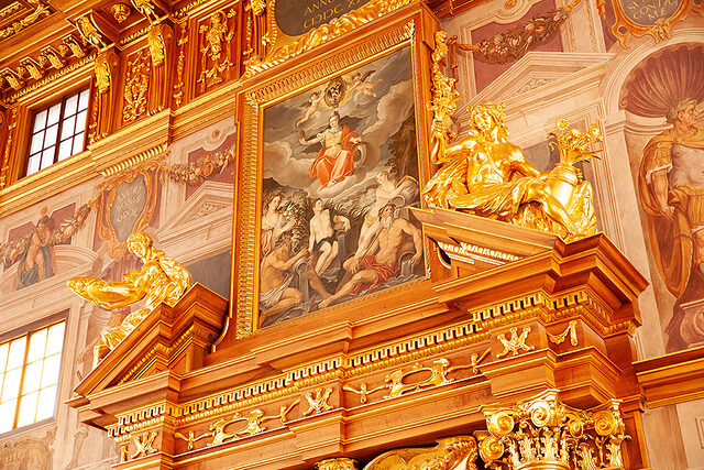 Das Ölgemälde über dem Eingangsportal wie auch die Wandfresken des Goldenen Saals im Augsburger Rathaus hat Hermenegild Peiker in den 80er Jahren restauriert. 